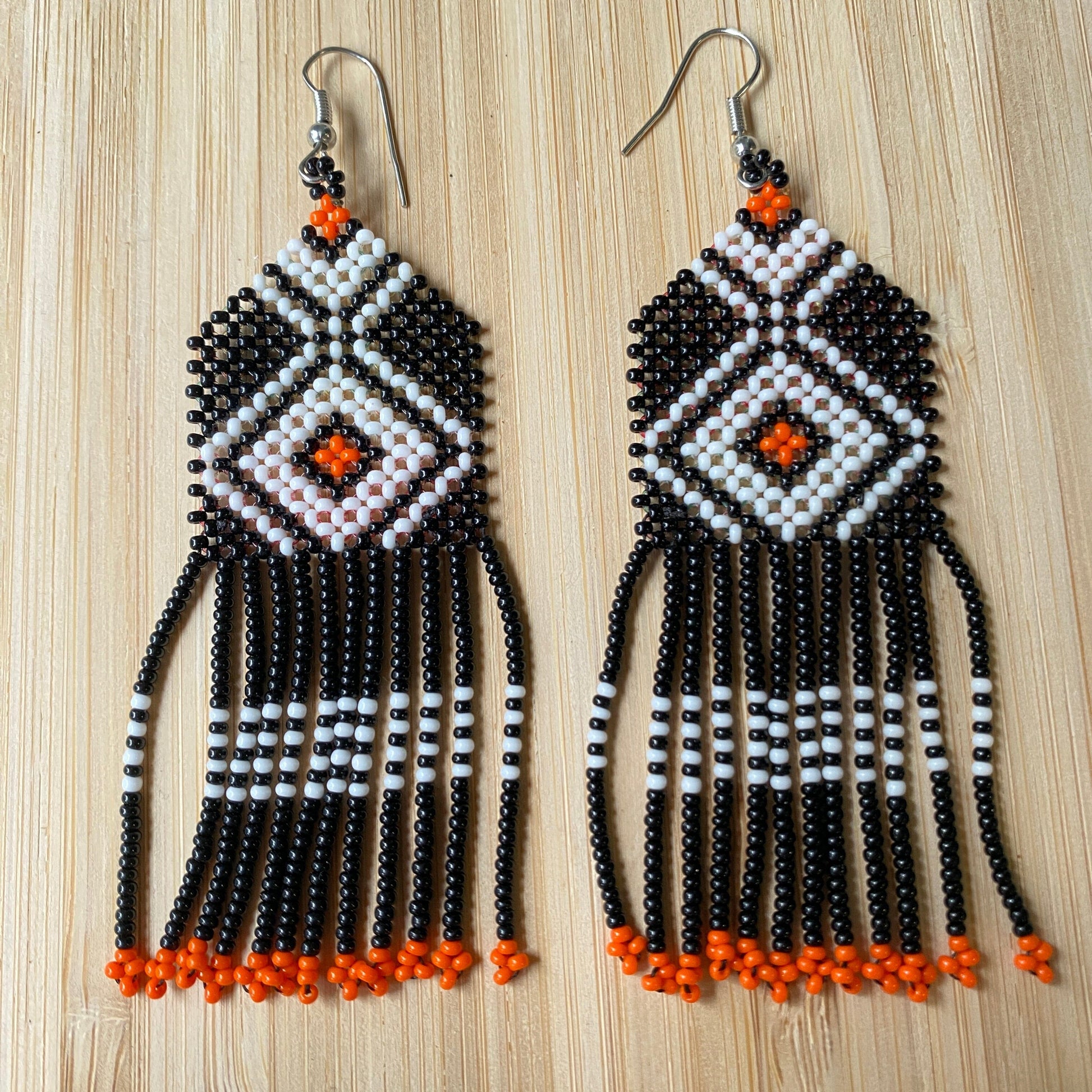 Boucles d'oreilles en perles de verre (miçanga) - Noir blanc et orange - Pointe orange - Ethnie Wai Wai Boucles d'oreilles Ethnie Wai Wai localisée dans les états de l' Amazonas, Pará et Roraima dans le Nord du Brésil. 