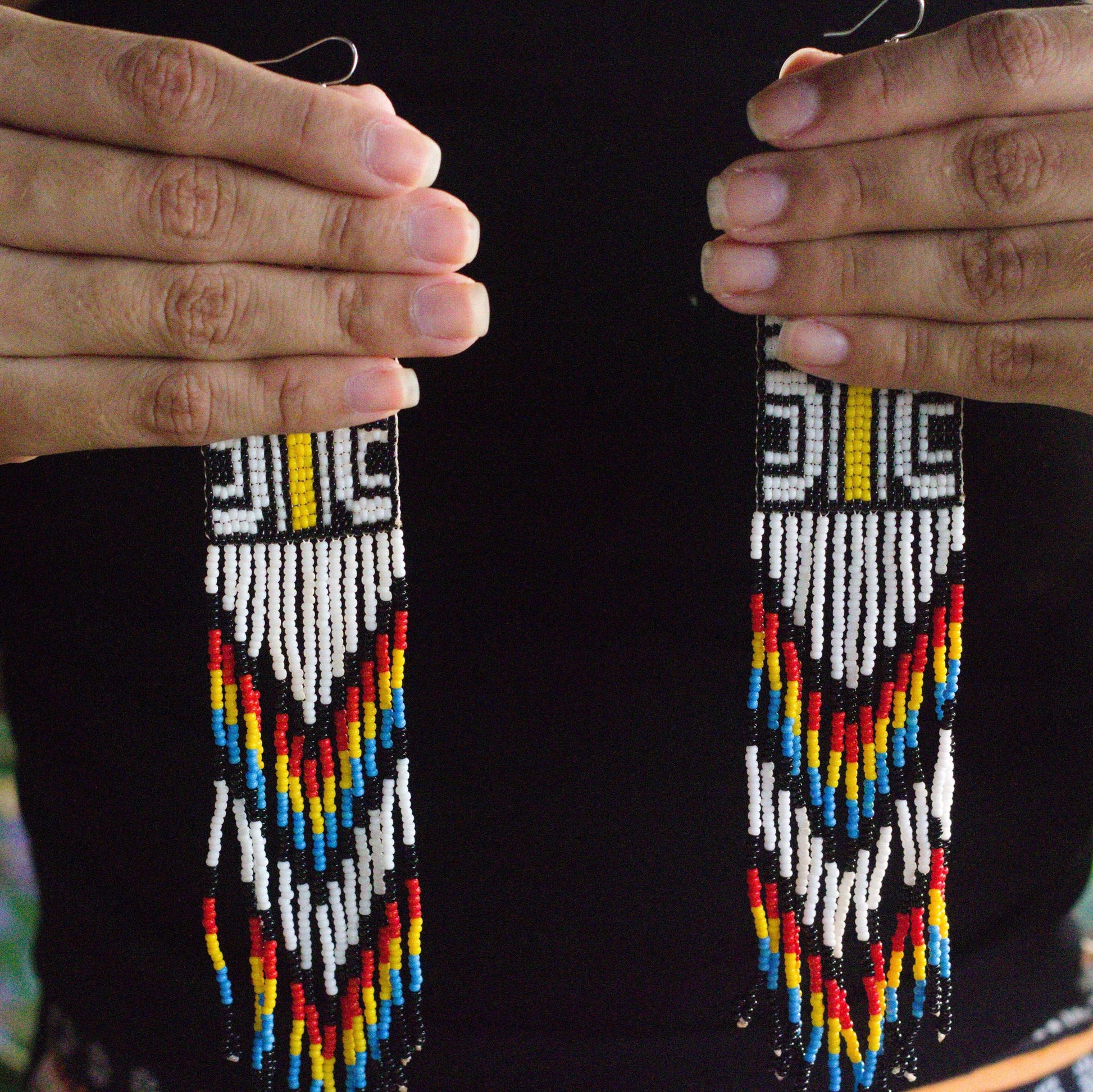 Boucles d'oreilles en perles de verre (miçanga) - noir et blanc ligne jaune - Ethnie Tapirapé Boucles d'oreilles Ethnie Tapirapé, localisée dans le Parc Indigène du Xingu dans l' état du Mato Grosso au Centre-Ouest du Brésil. 