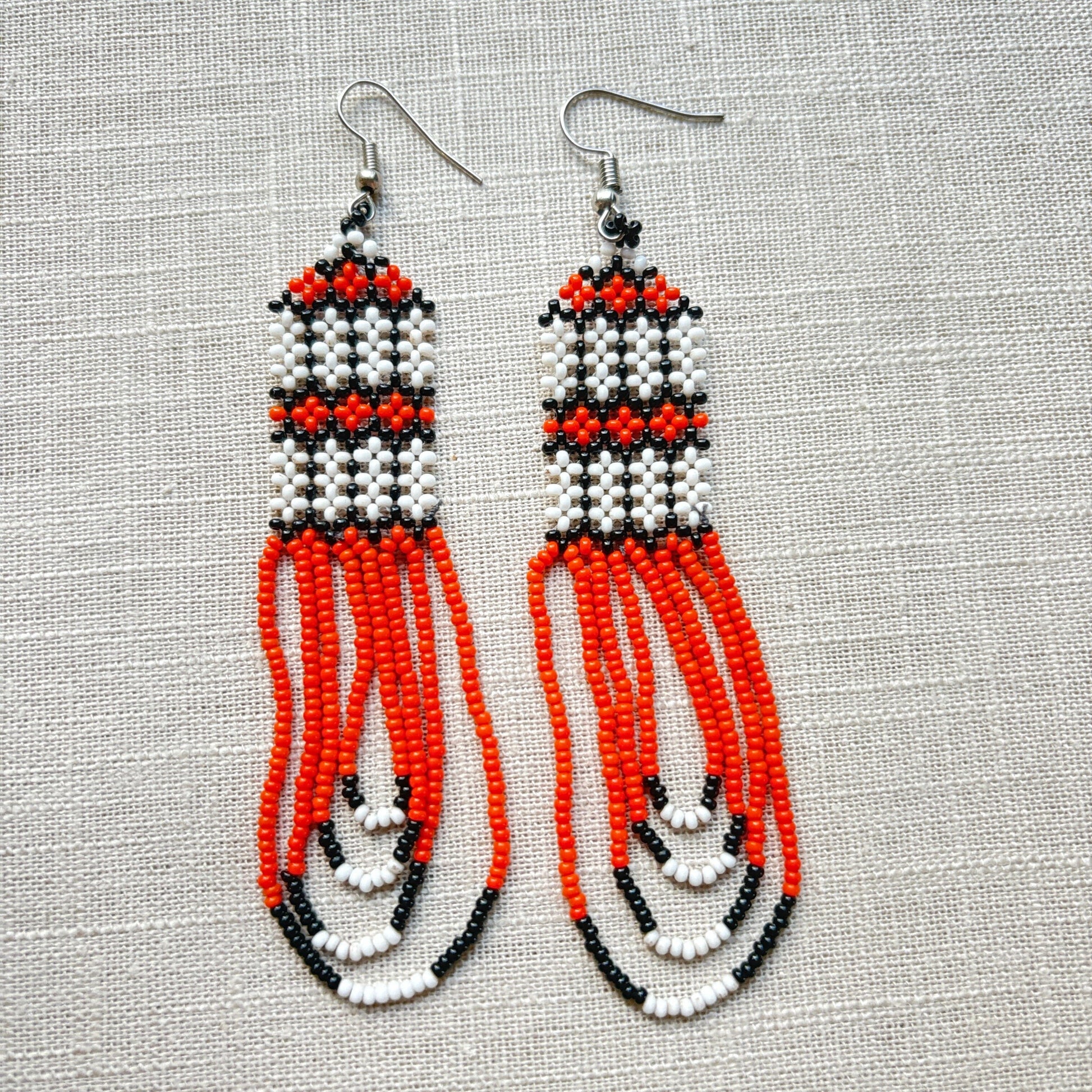 Boucles d'oreilles en perles de verre (miçanga) - orange et blanc - Ethnie Kayapo Boucles d'oreilles Ethnie Kayapo, localisée dans l'état du Pará au nord du Brésil 
