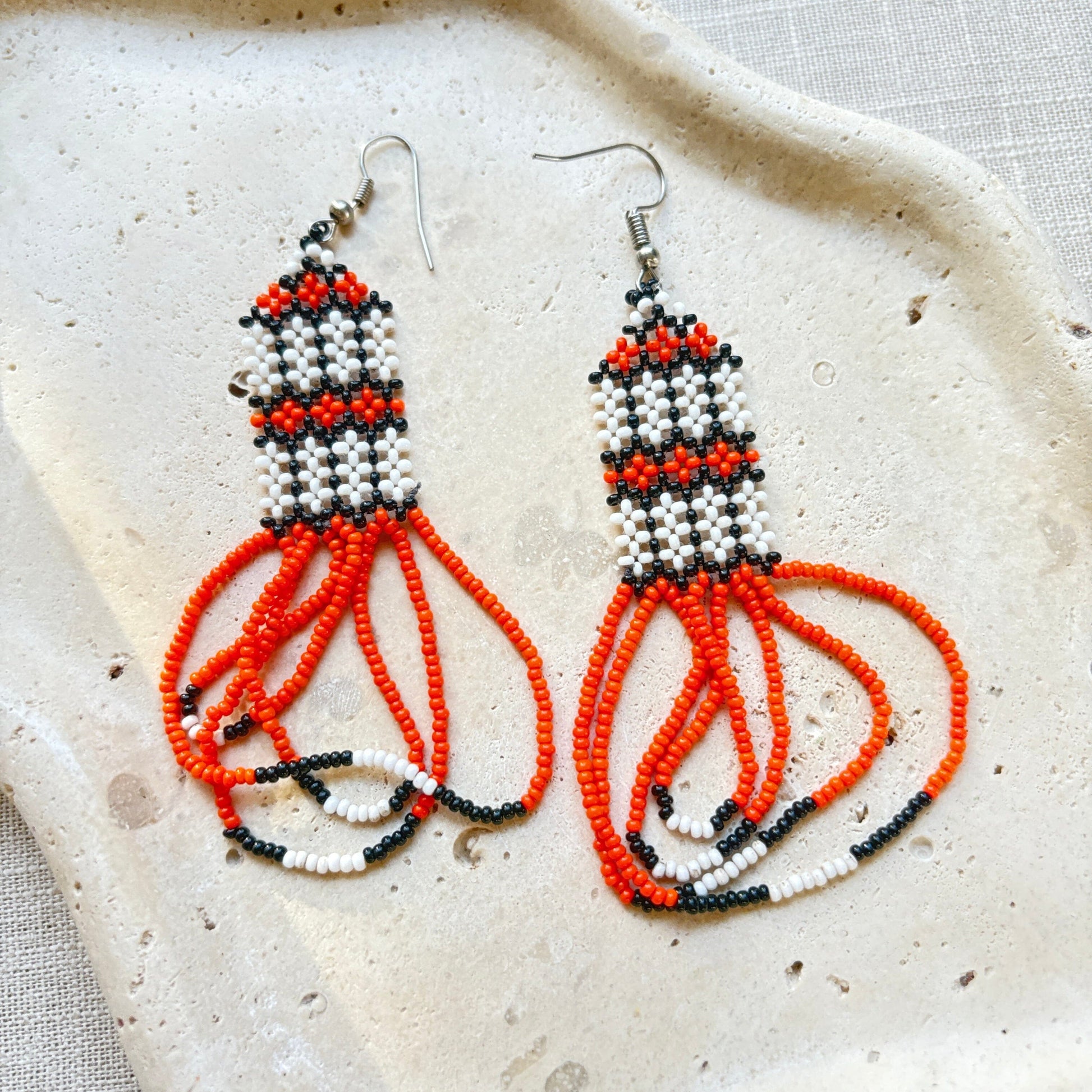 Boucles d'oreilles en perles de verre (miçanga) - orange et blanc - Ethnie Kayapo Boucles d'oreilles Ethnie Kayapo, localisée dans l'état du Pará au nord du Brésil 