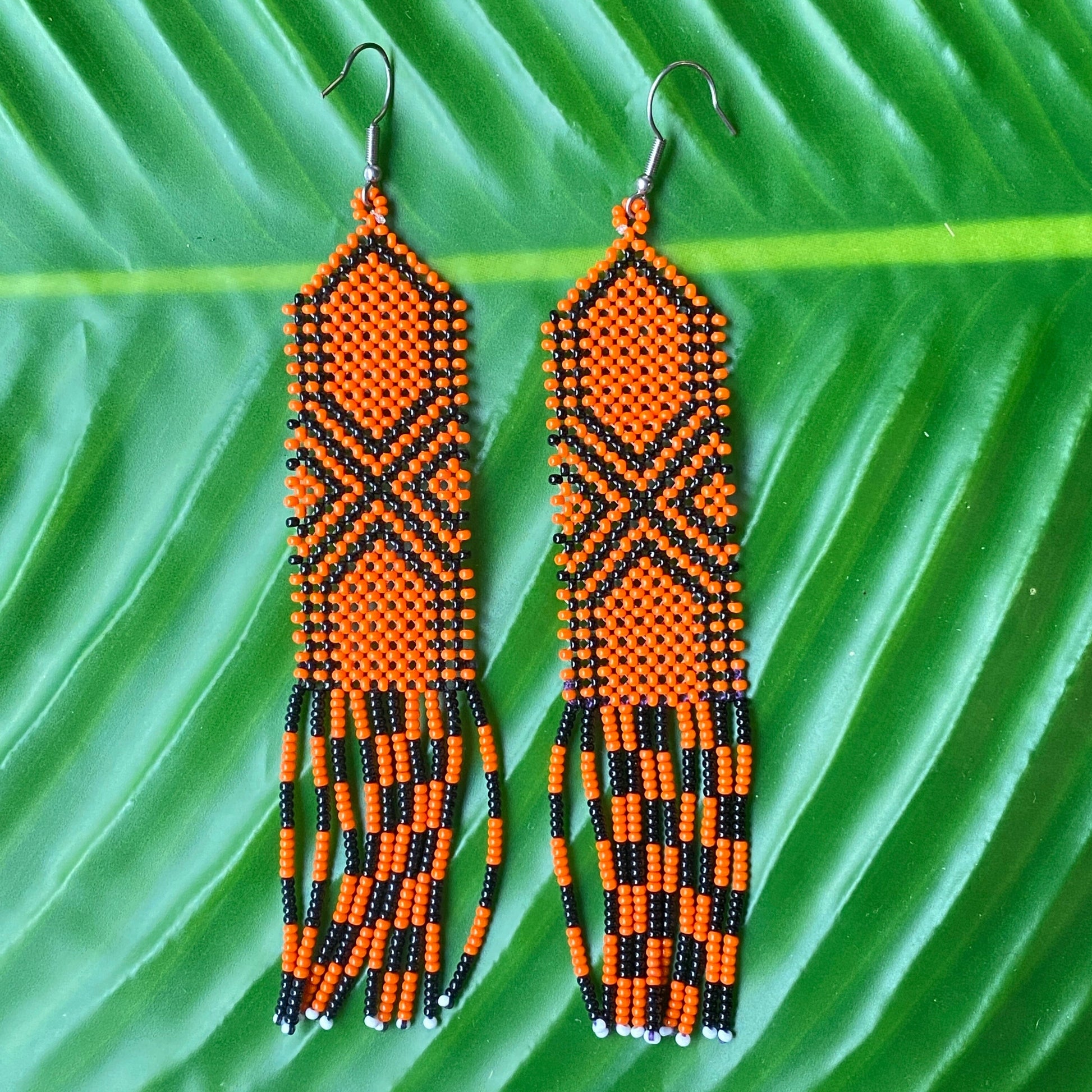 Boucles d'oreilles en perles de verre (Miçanga) - orange et noir - Ethnie Kayapo Boucles d'oreilles Ethnie Kayapo, localisée dans l'état du Pará au nord du Brésil 