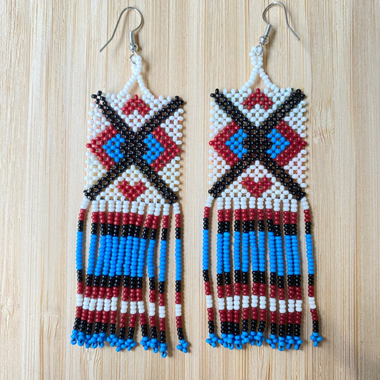 Boucles d'oreilles Miçanga - Blanc bleu croix noir - Ethnie Wai Wai Boucles d'oreilles Ethnie Wai Wai localisée dans les états de l' Amazonas, Pará et Roraima dans le Nord du Brésil. 