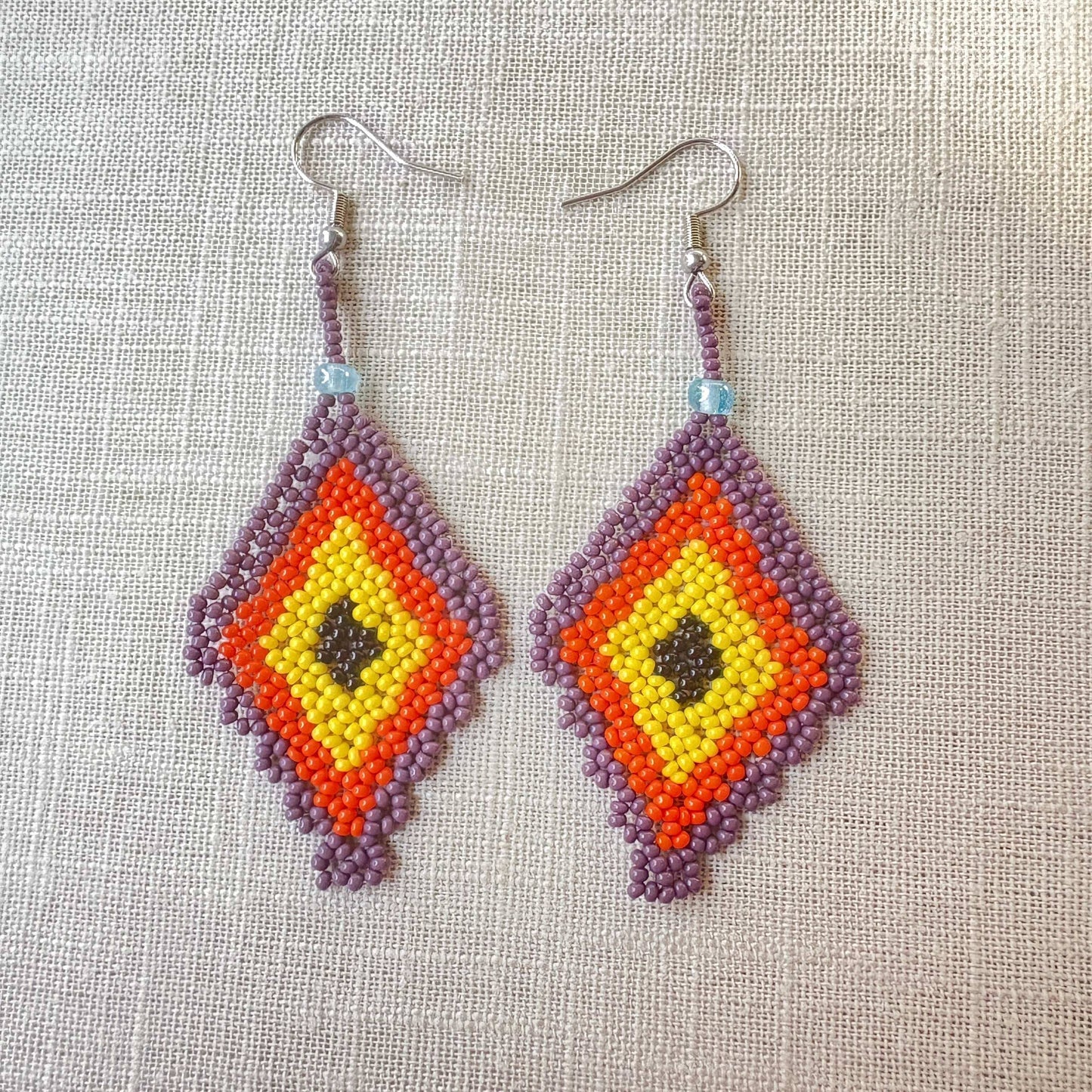 Boucles d'oreilles Miçanga - Losange violet orange jaune et noir - Ethnie Kayapo Boucles d'oreilles Ethnie Kayapo, localisée dans l'état du Pará au nord du Brésil 