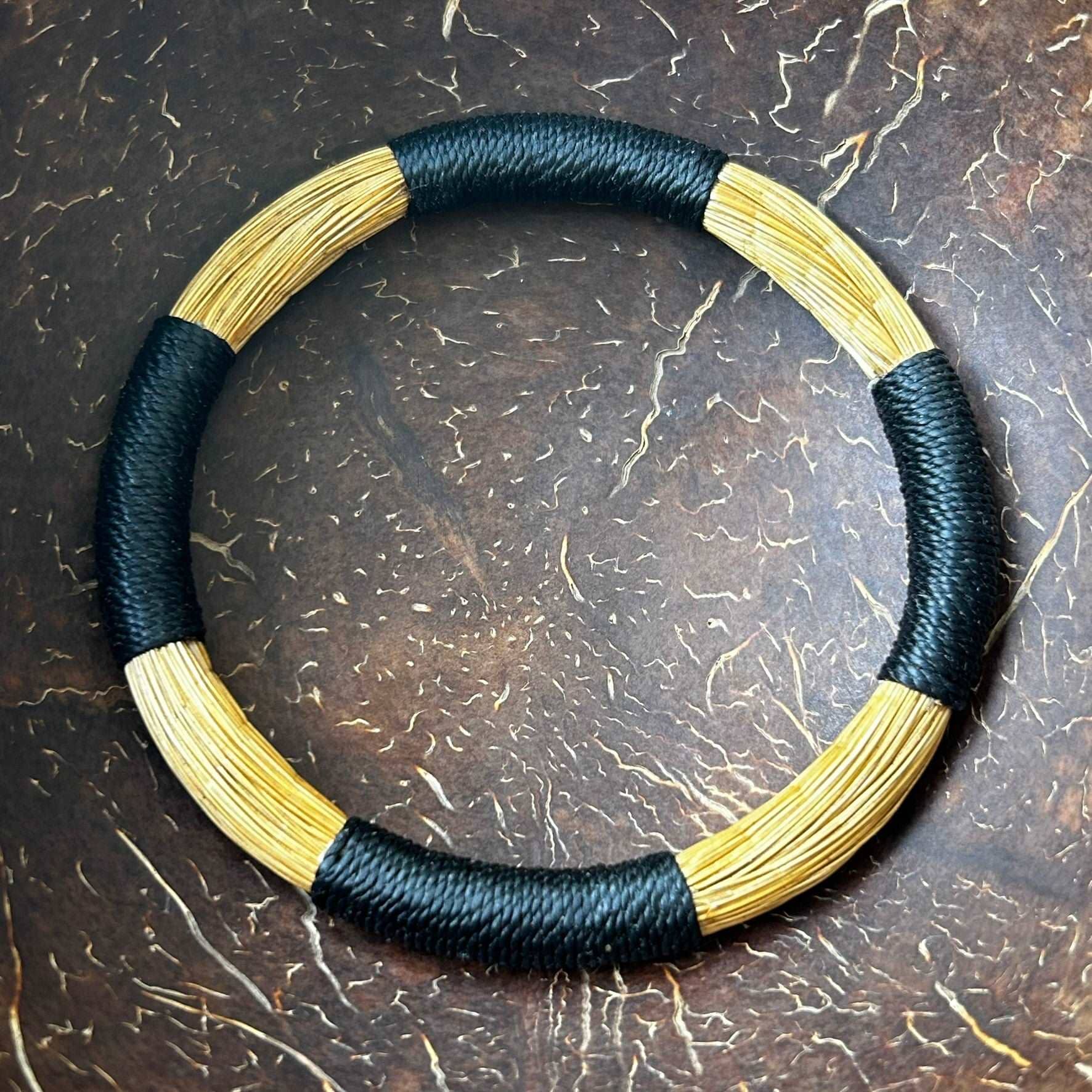 Bracelet Capim Dourado entouré de fils de palmier buriti teinté noir Bracelet Artisan local travaillant le Capim Dourado dans l'état du Tocantins au centre-est du Brésil 