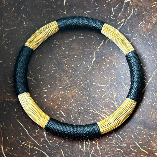 Bracelet Capim Dourado entouré de fils de palmier buriti teinté noir Bracelet Artisan local travaillant le Capim Dourado dans l'état du Tocantins au centre-est du Brésil 