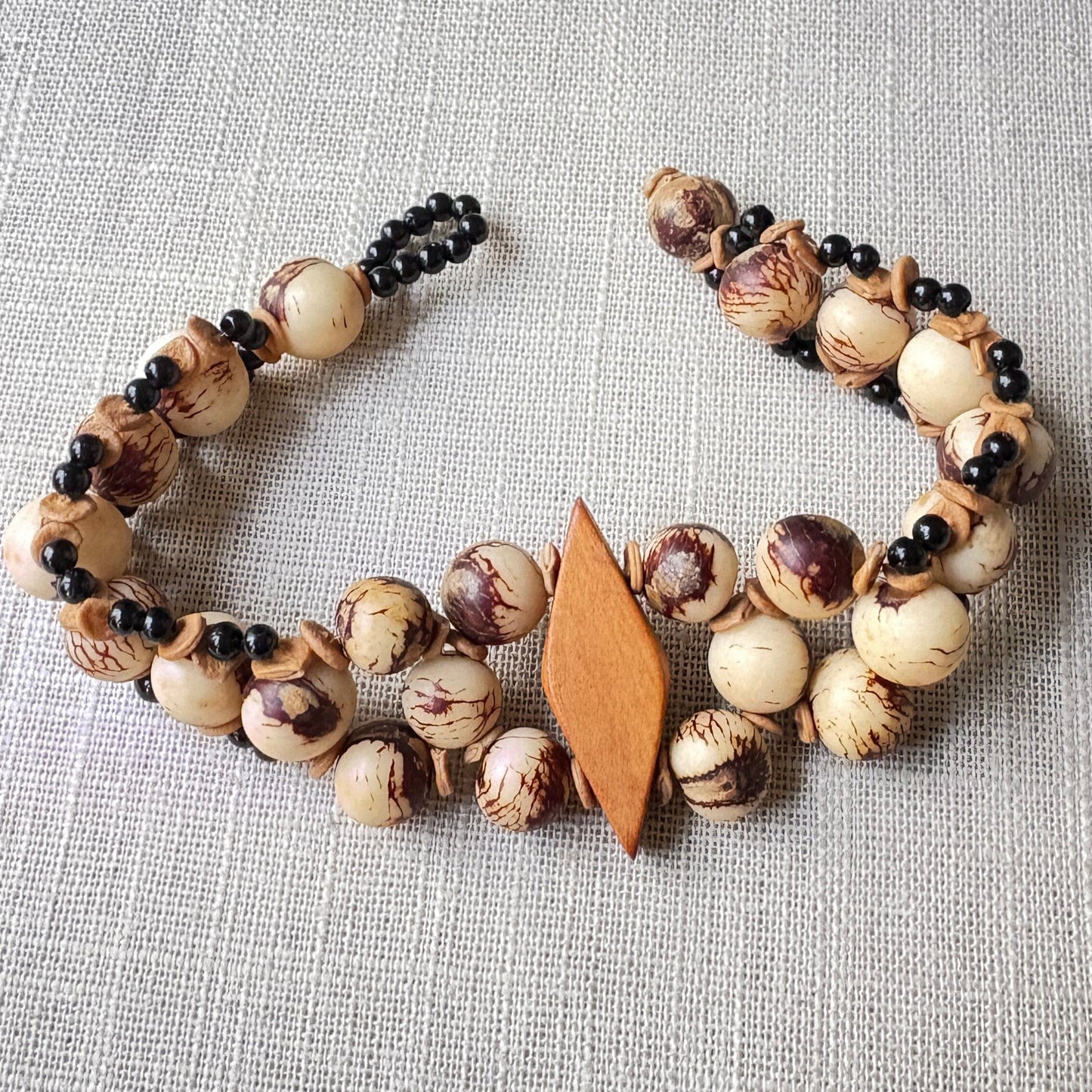 Bracelet de graines d'açai naturel et bois losange - Ethnie Sateré Mawé Bracelet Ethnie Sateré Mawé localisée dans les états de l'Amazonas et du Pará dans le Nord du Brésil. 