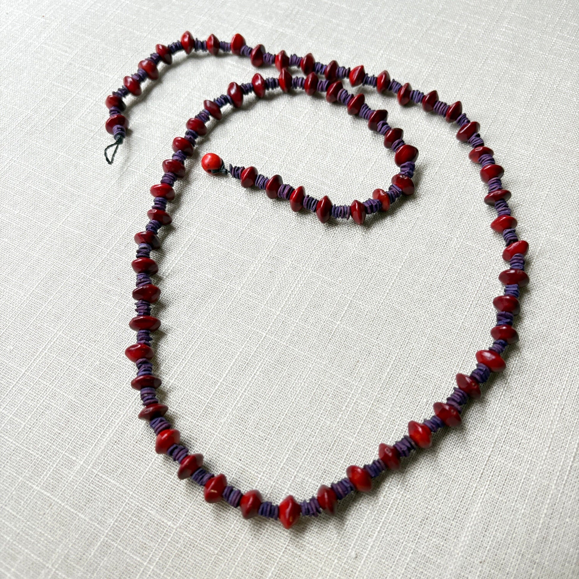 Collier de graines de morototo teintées violettes et graines de Pau Brasil Collier Communauté Jamaraqua, située sur la rive du fleuve Tapajos, état du Para. 