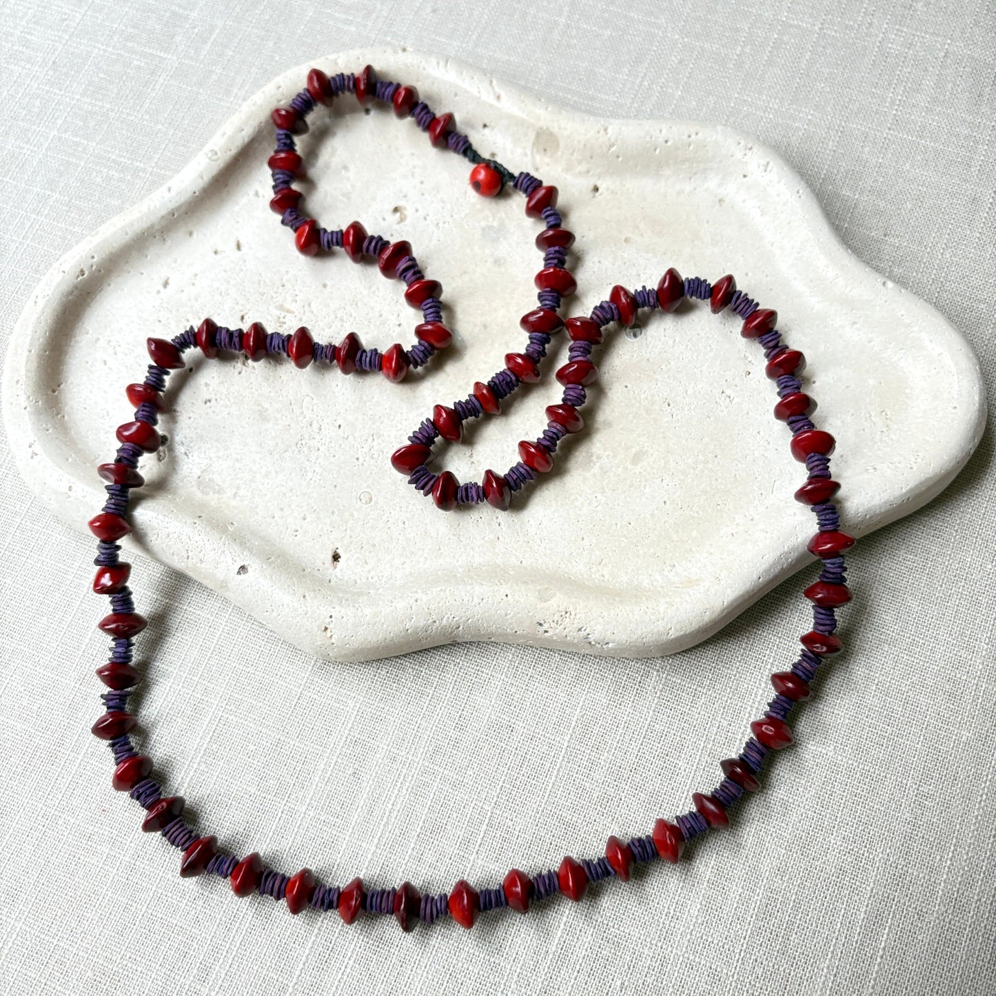 Collier de graines de morototo teintées violettes et graines de Pau Brasil Collier Communauté Jamaraqua, située sur la rive du fleuve Tapajos, état du Para. 