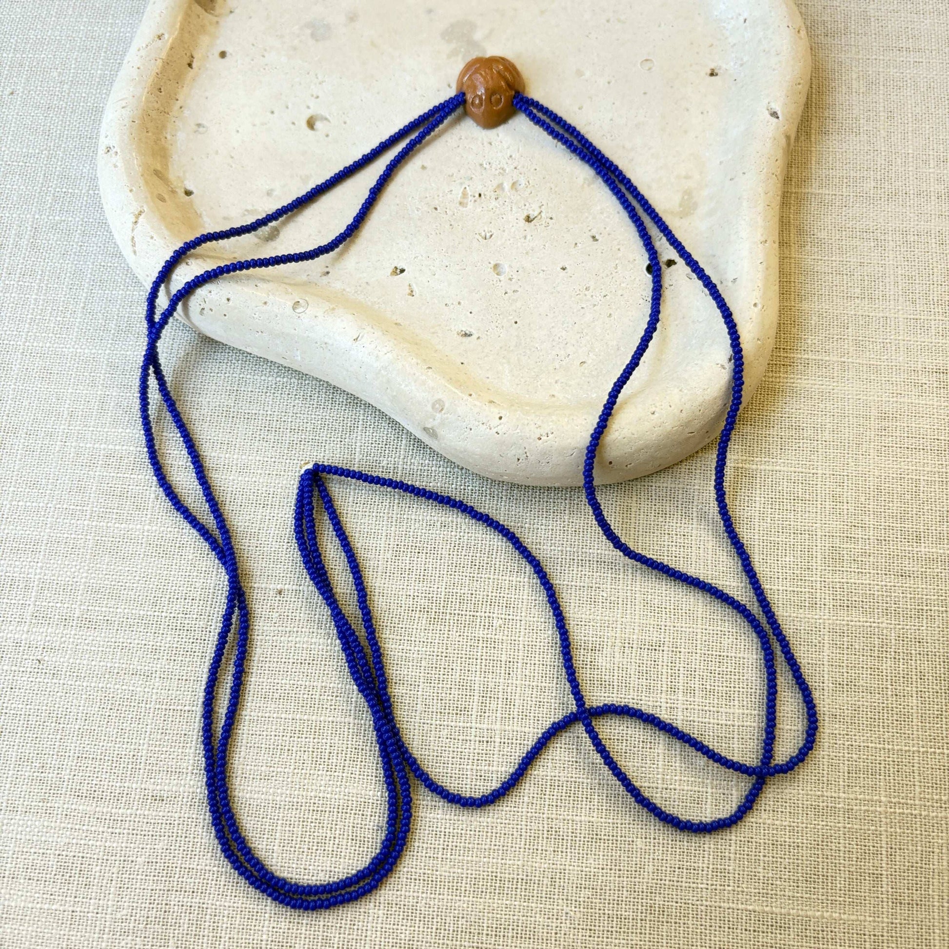 Collier en perles de verre (Miçanga) - bleu et pendentif Muiraquitã - Ethnie Borari Collier Ethnie Borari, localisée dans l'état du Pará dans le Nord du Brésil. 