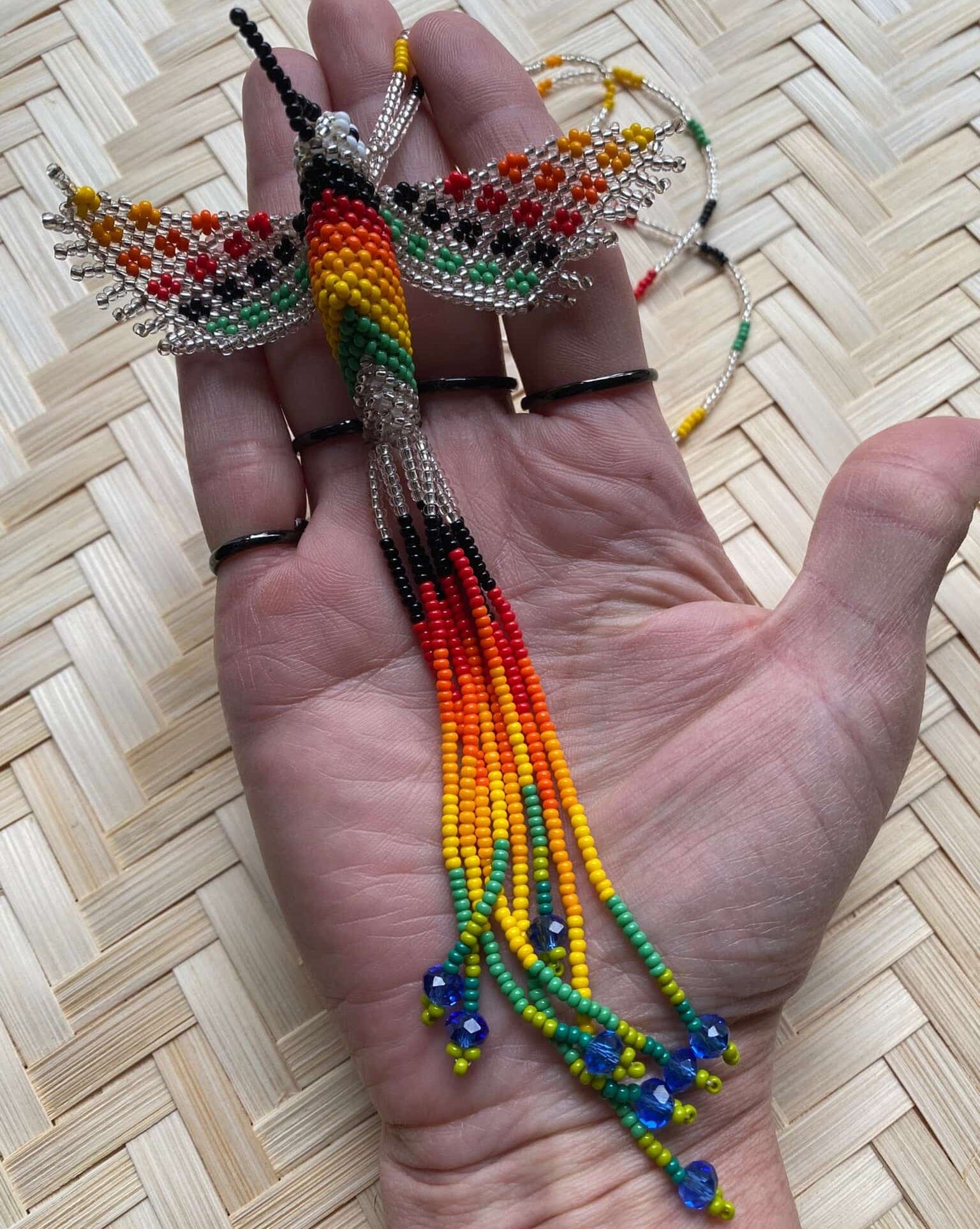 Collier en perles de verre (Miçanga) - Colibri - argenté et multicolore - Ethnie Mehinako Collier Ethnie Mehinako, localisée dans le Parc Indigène du Xingu dans l' état du Mato Grosso au Centre-Ouest du Brésil. 