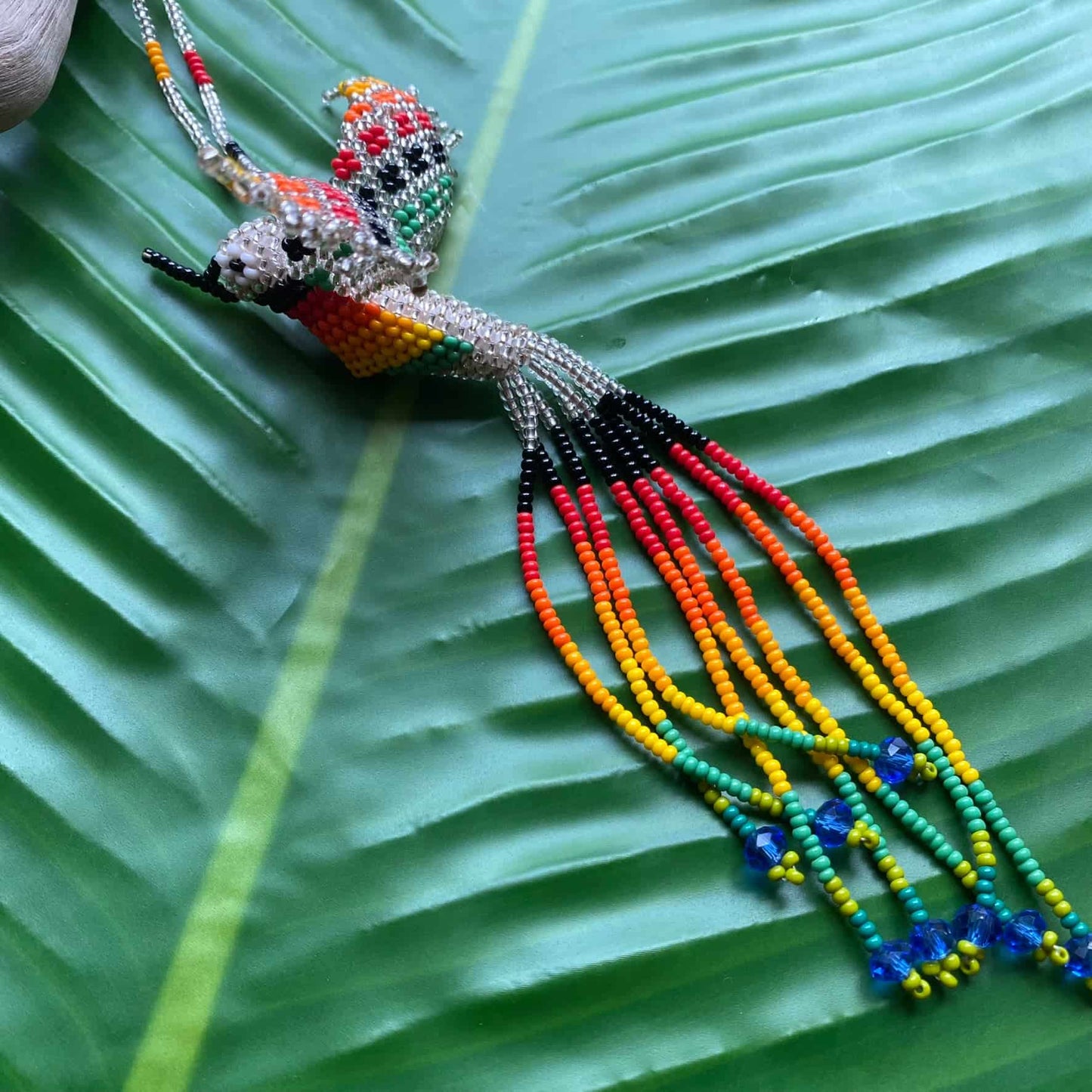 Collier en perles de verre (Miçanga) - Colibri - argenté et multicolore - Ethnie Mehinako Collier Ethnie Mehinako, localisée dans le Parc Indigène du Xingu dans l' état du Mato Grosso au Centre-Ouest du Brésil. 