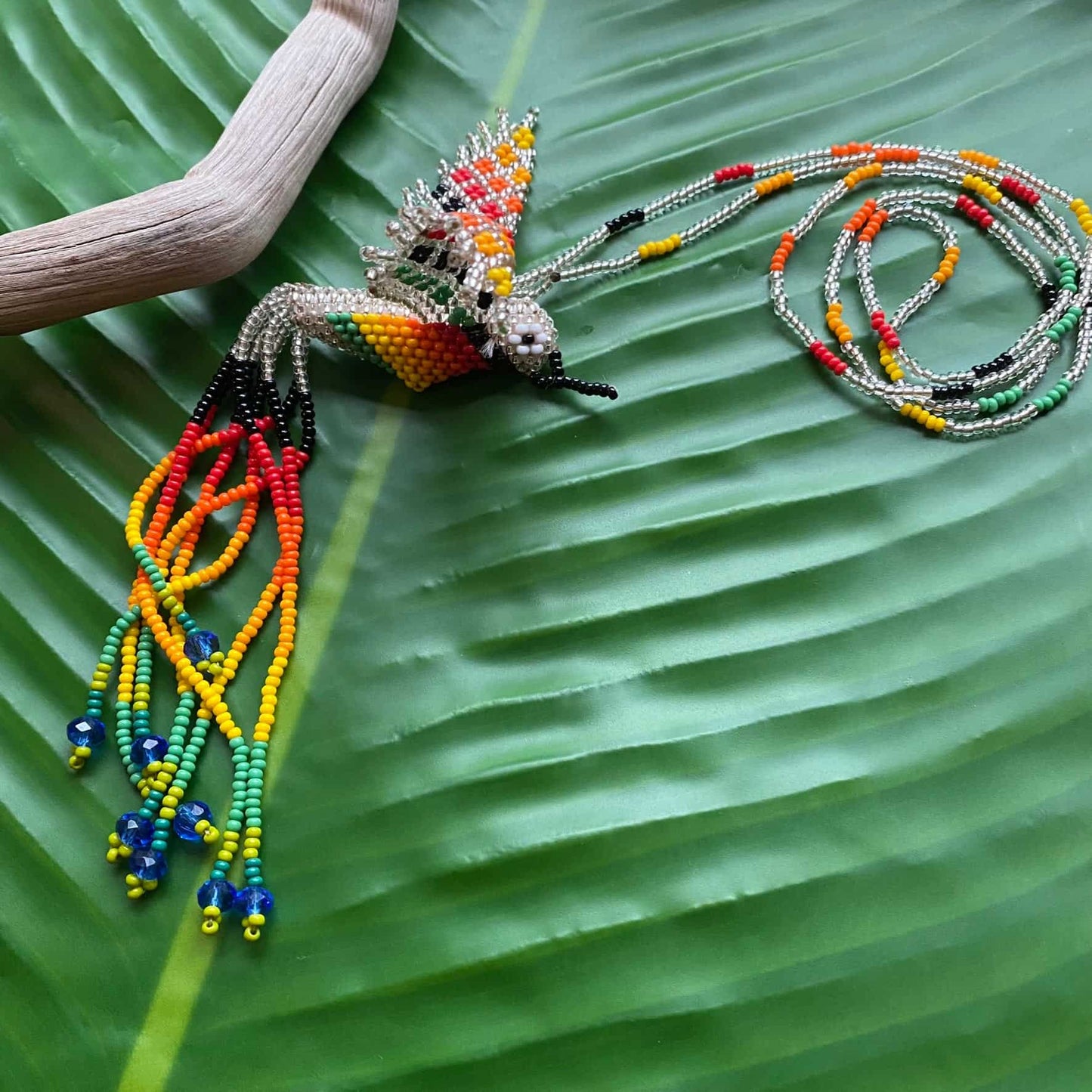 Collier en perles de verre (Miçanga) - Colibri - argenté et multicolore - Ethnie Mehinako Collier Ethnie Mehinako, localisée dans le Parc Indigène du Xingu dans l' état du Mato Grosso au Centre-Ouest du Brésil. 