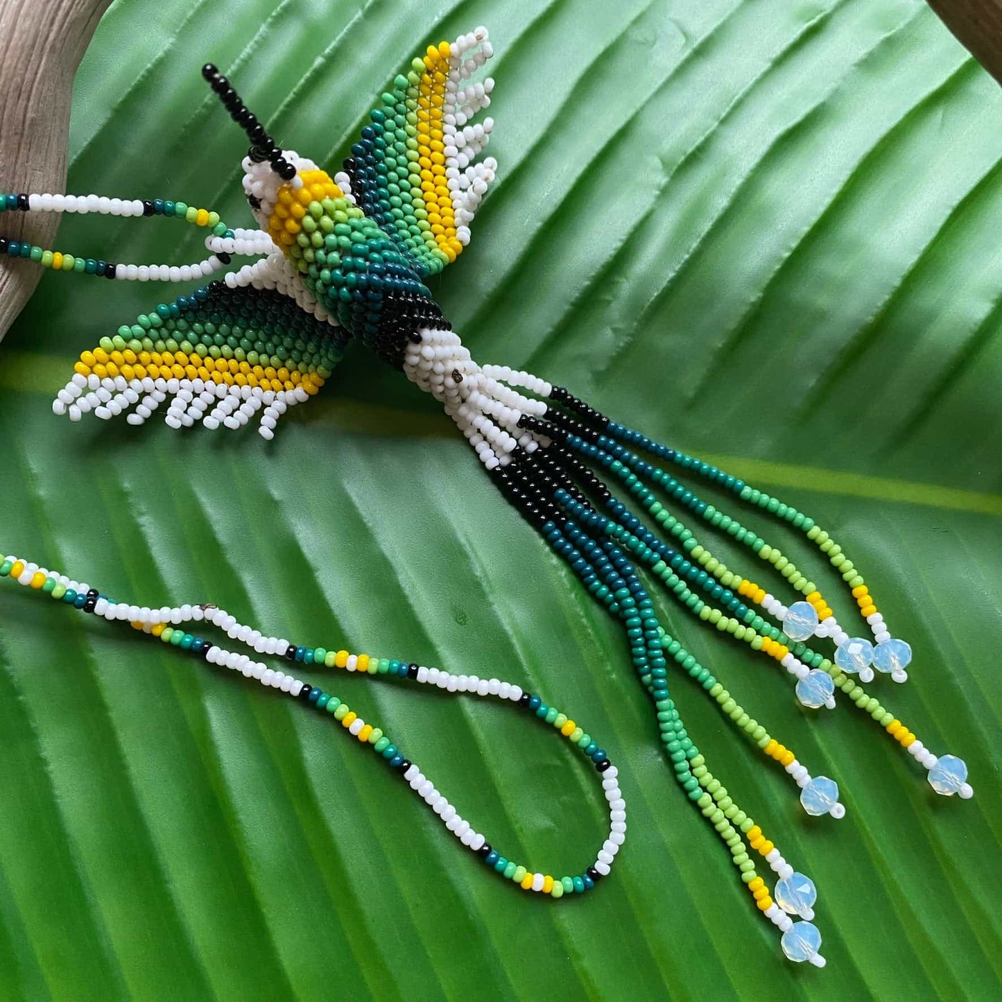 Collier en perles de verre (miçanga) - Colibri - blanc et vert - Ethnie Mehinako Collier Ethnie Mehinako, localisée dans le Parc Indigène du Xingu dans l' état du Mato Grosso au Centre-Ouest du Brésil. 