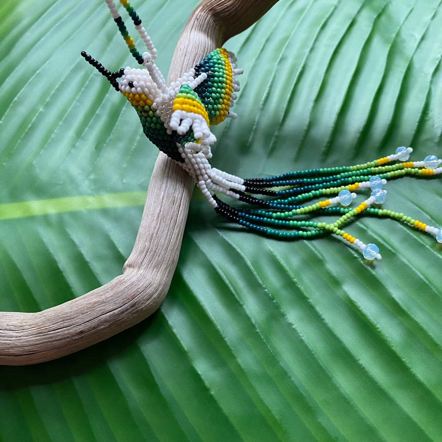 Collier en perles de verre (miçanga) - Colibri - blanc et vert - Ethnie Mehinako Collier Ethnie Mehinako, localisée dans le Parc Indigène du Xingu dans l' état du Mato Grosso au Centre-Ouest du Brésil. 