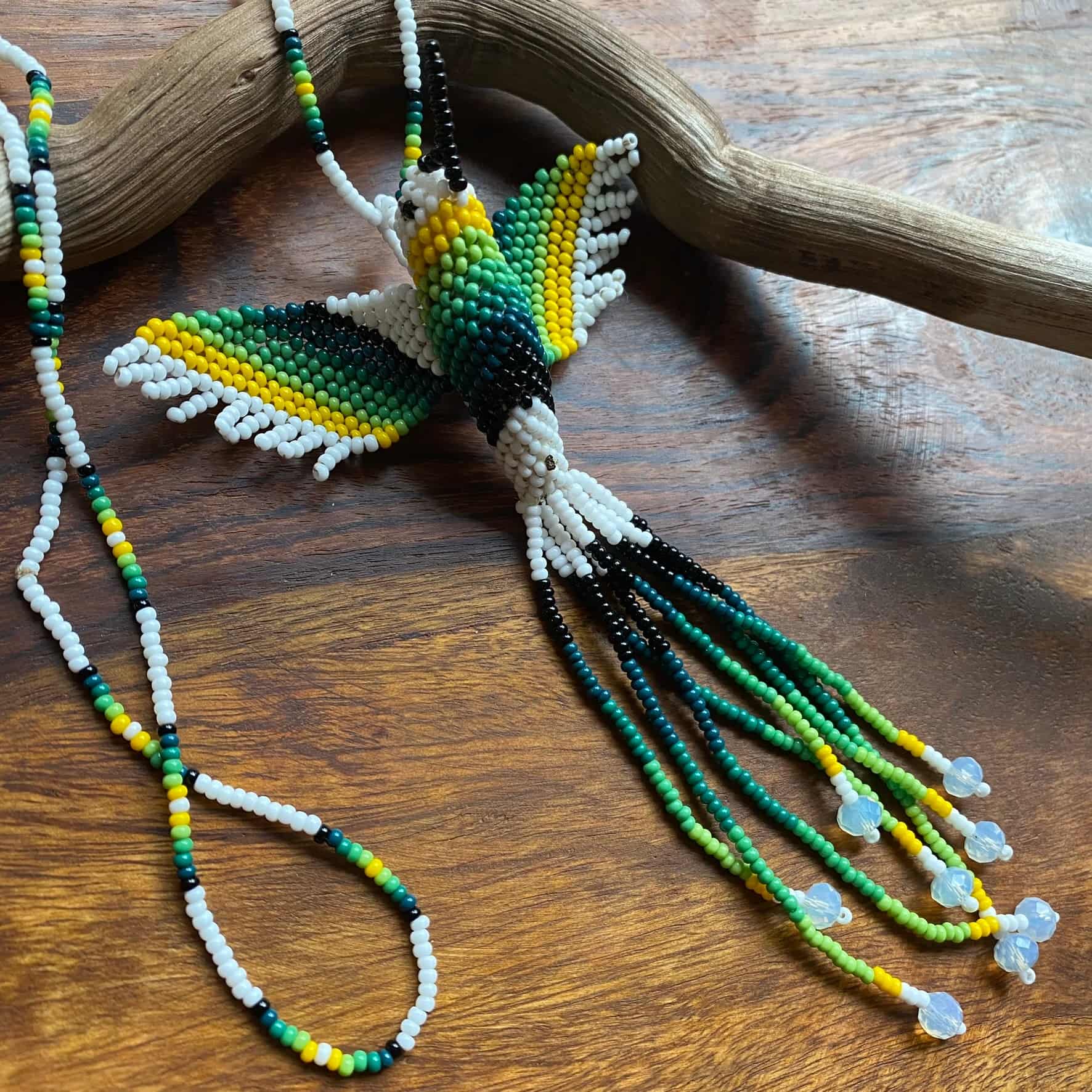 Collier en perles de verre (miçanga) - Colibri - blanc et vert - Ethnie Mehinako Collier Ethnie Mehinako, localisée dans le Parc Indigène du Xingu dans l' état du Mato Grosso au Centre-Ouest du Brésil. 