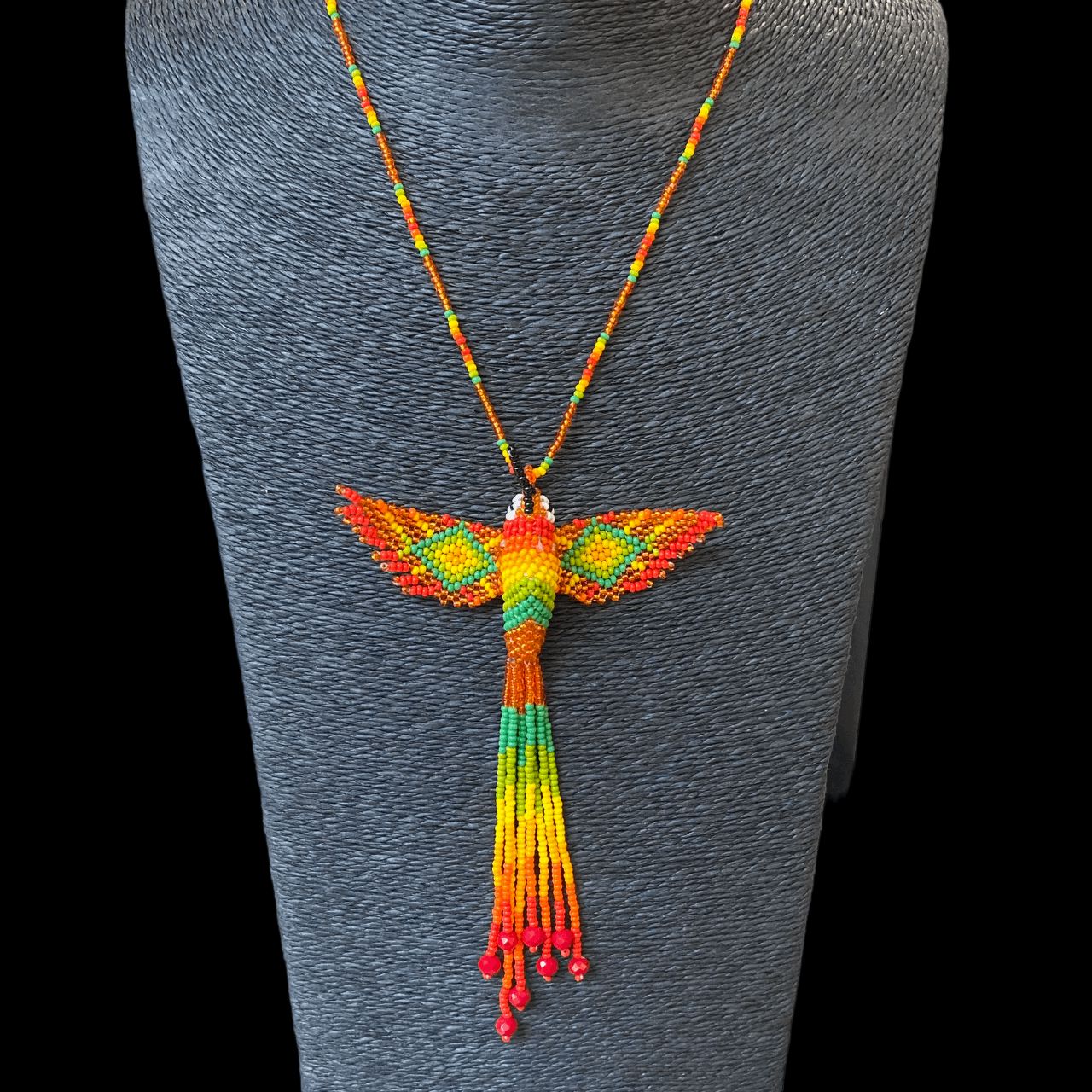Collier en perles de verre (Miçanga) - Colibri - orange et vert - Ethnie Mehinako Collier Ethnie Mehinako, localisée dans le Parc Indigène du Xingu dans l' état du Mato Grosso au Centre-Ouest du Brésil. 