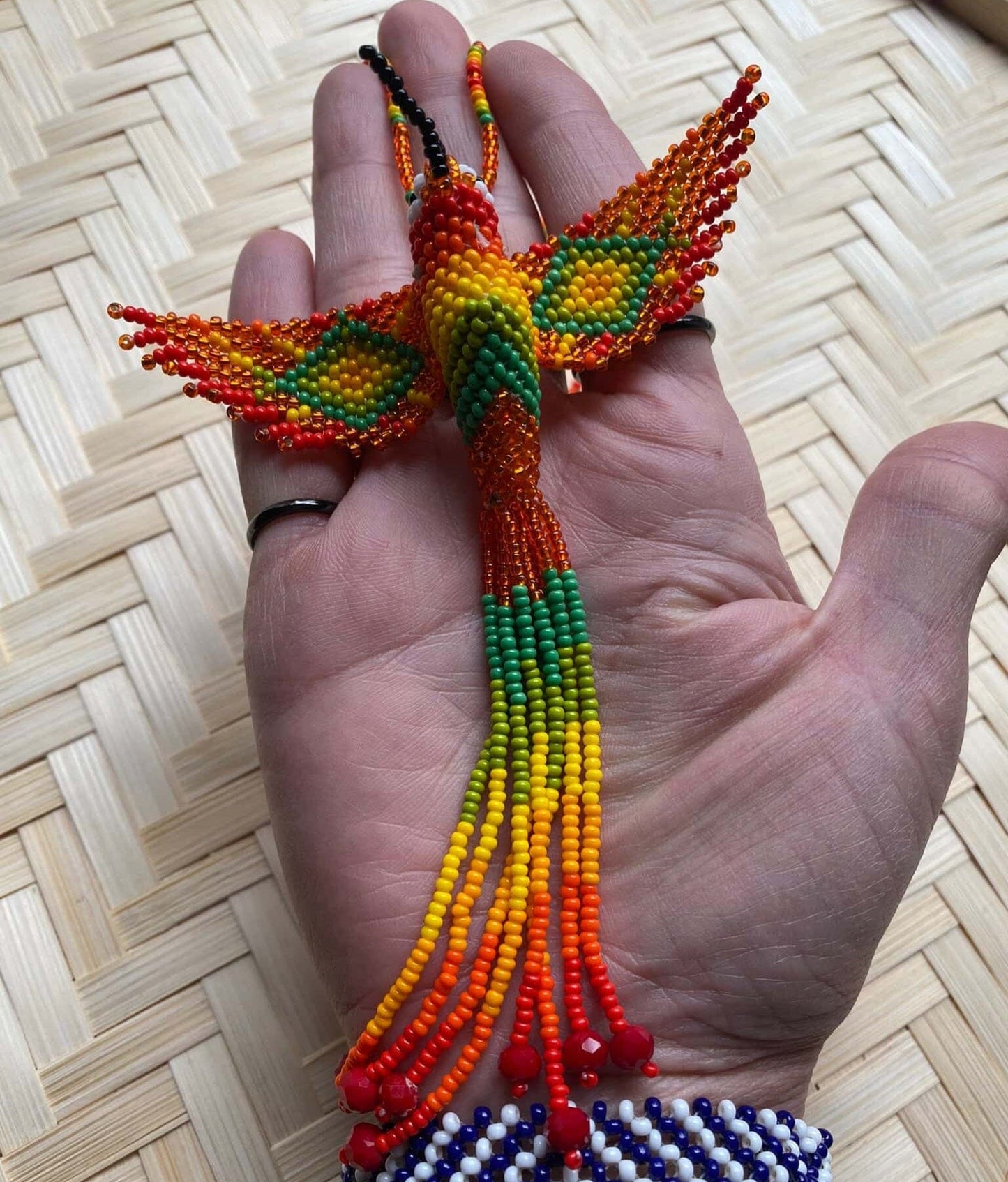 Collier en perles de verre (Miçanga) - Colibri - orange et vert - Ethnie Mehinako Collier Ethnie Mehinako, localisée dans le Parc Indigène du Xingu dans l' état du Mato Grosso au Centre-Ouest du Brésil. 