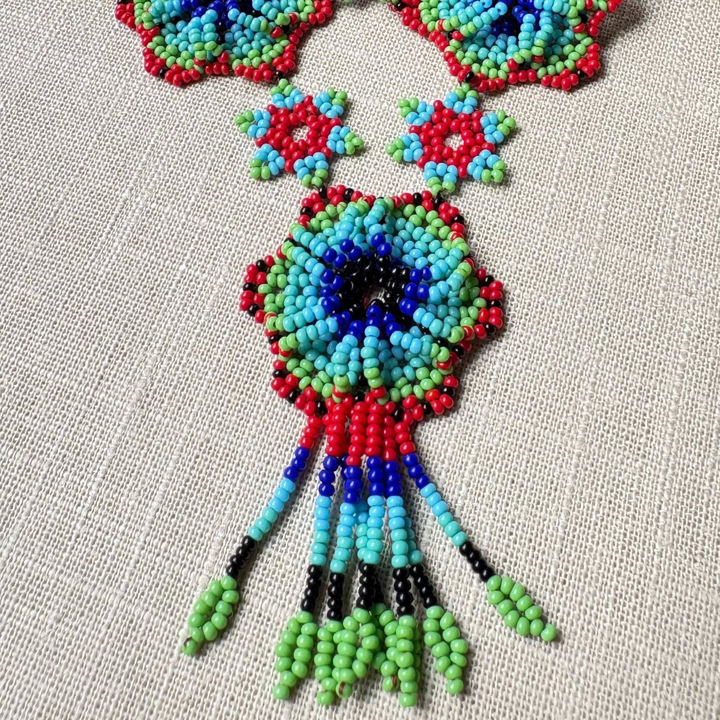 Collier en perles de verre (Miçanga) multicolore - fleurs bleu vert et rouge - Ethnie Arapiun Collier Ethnie Arapiun, localisée dans l'Etat du Para au Nord du Brésil. 