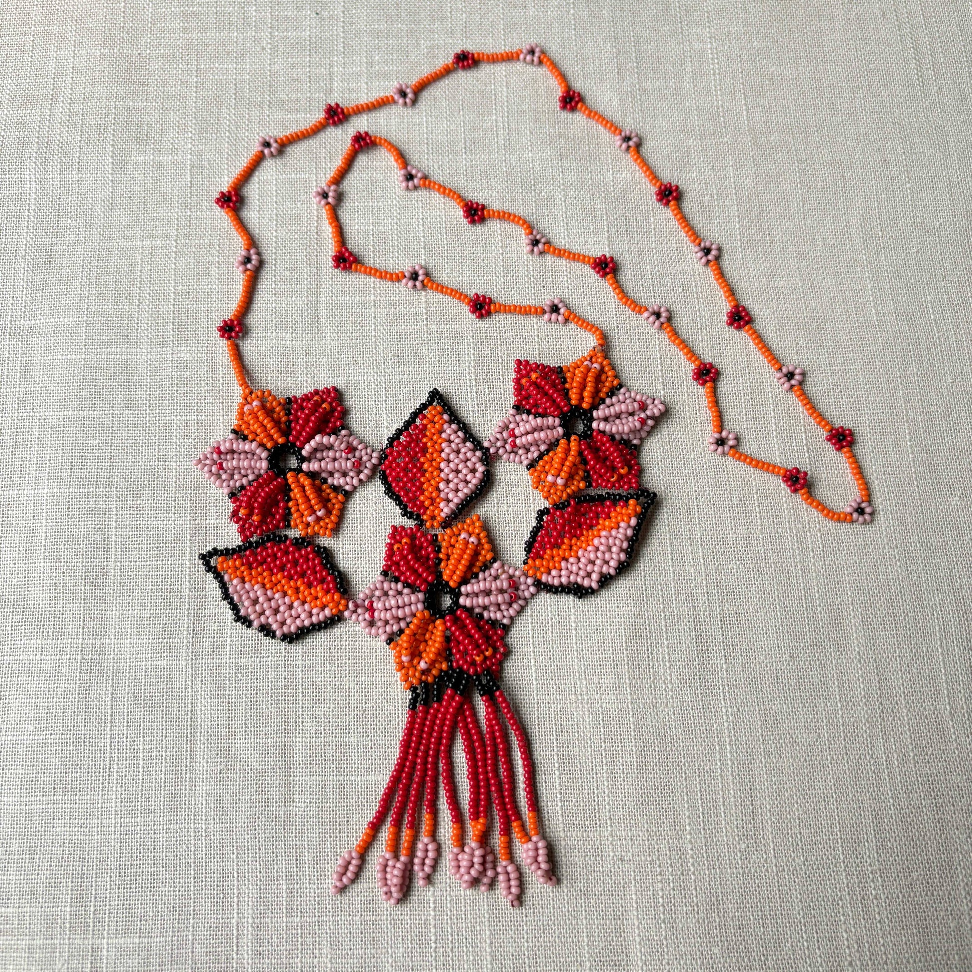 Collier en perles de verre (miçanga) multicolore - fleurs rouge orange et rose - Ethnie Arapiun Collier Ethnie Arapiun, localisée dans l'Etat du Para au Nord du Brésil. 