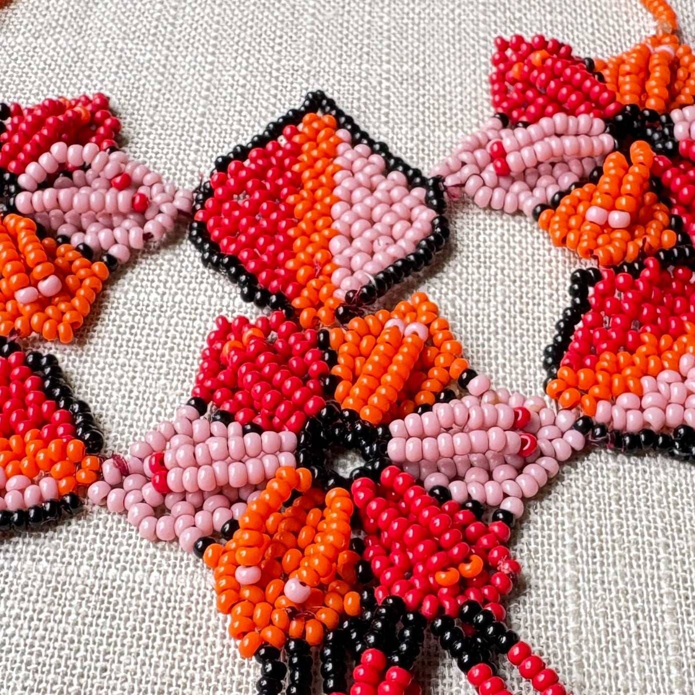 Collier en perles de verre (miçanga) multicolore - fleurs rouge orange et rose - Ethnie Arapiun Collier Ethnie Arapiun, localisée dans l'Etat du Para au Nord du Brésil. 