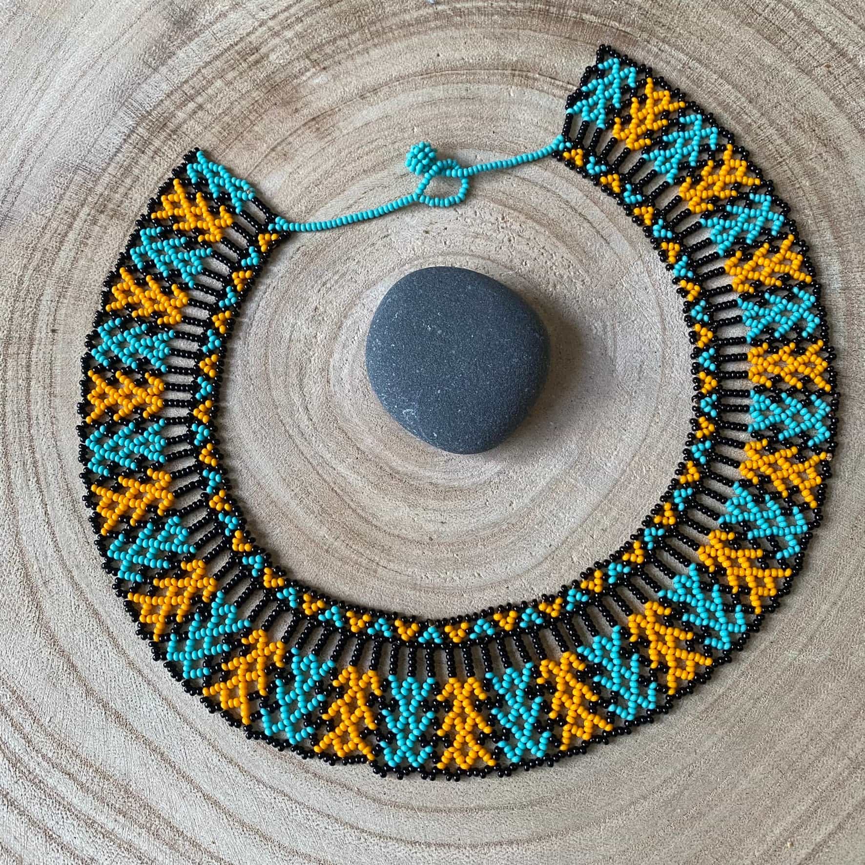 Collier en perles de verre (Miçanga) - noir bleu et orange - Ethnie Mehinako Collier Ethnie Mehinako, localisée dans le Parc Indigène du Xingu dans l' état du Mato Grosso au Centre-Ouest du Brésil. 