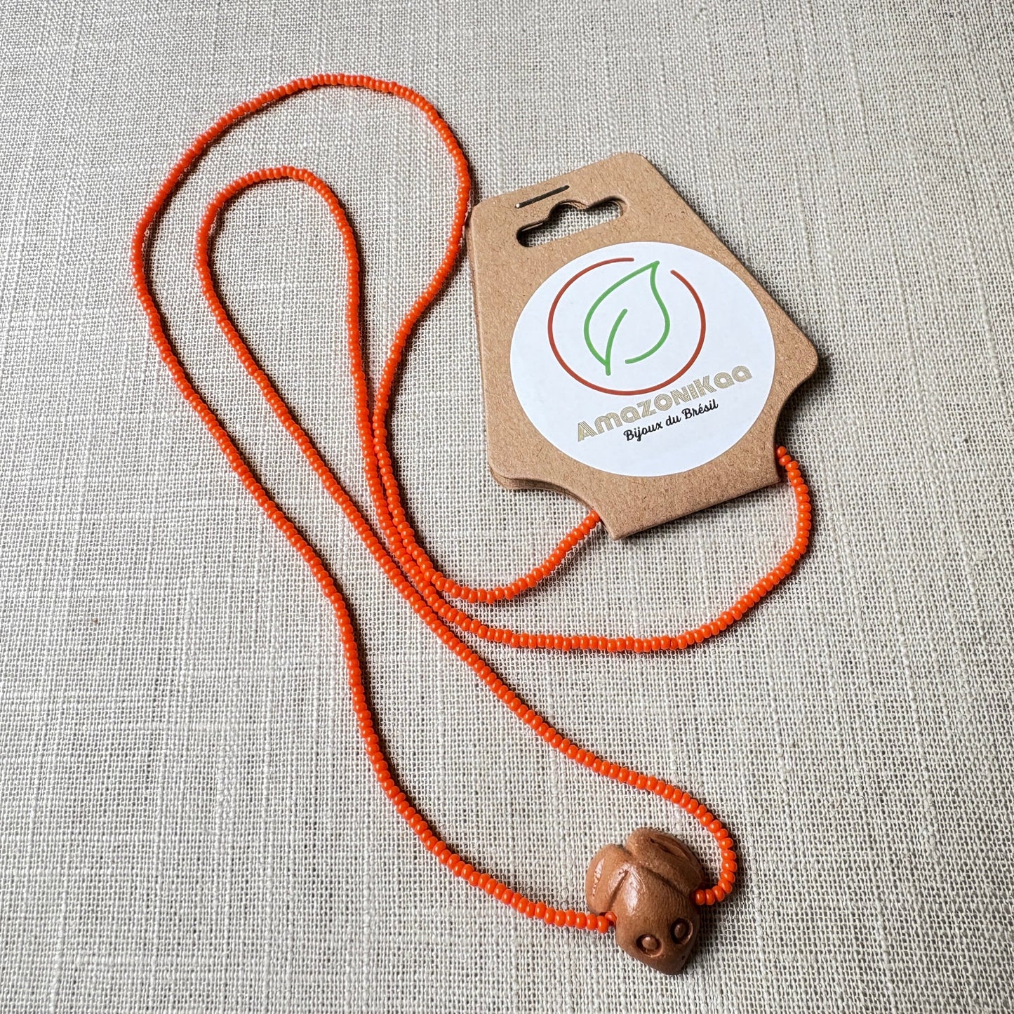 Collier en perles de verre (Miçanga) - orange et pendentif Muiraquitã - Ethnie Borari Collier Ethnie Borari, localisée dans l'état du Pará dans le Nord du Brésil. 