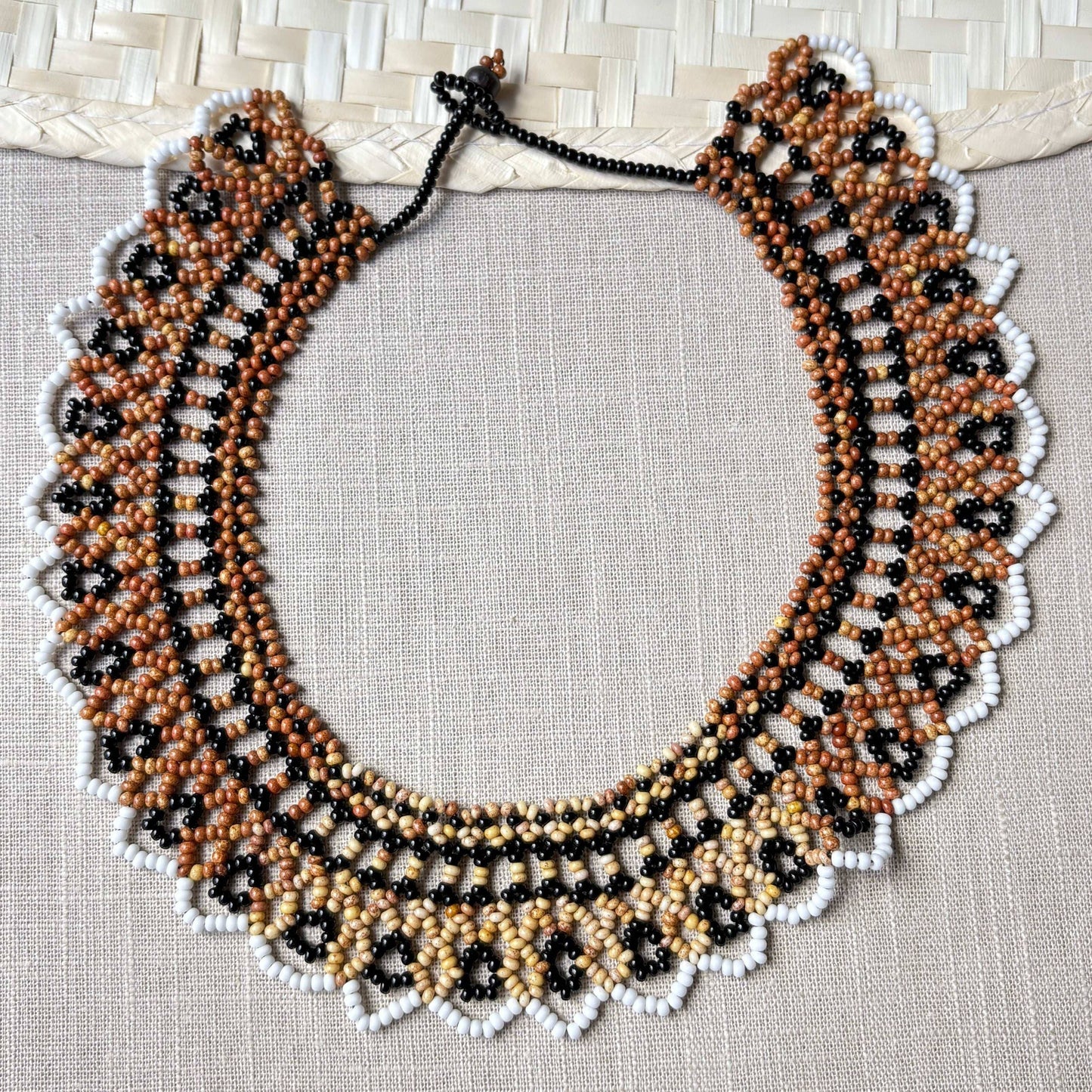 Collier en perles de verre (miçanga) ras de cou marron noir blanc et beige - Ethnie Wai Wai Collier Ethnie Wai Wai localisée dans les états de l' Amazonas, Pará et Roraima dans le Nord du Brésil. 