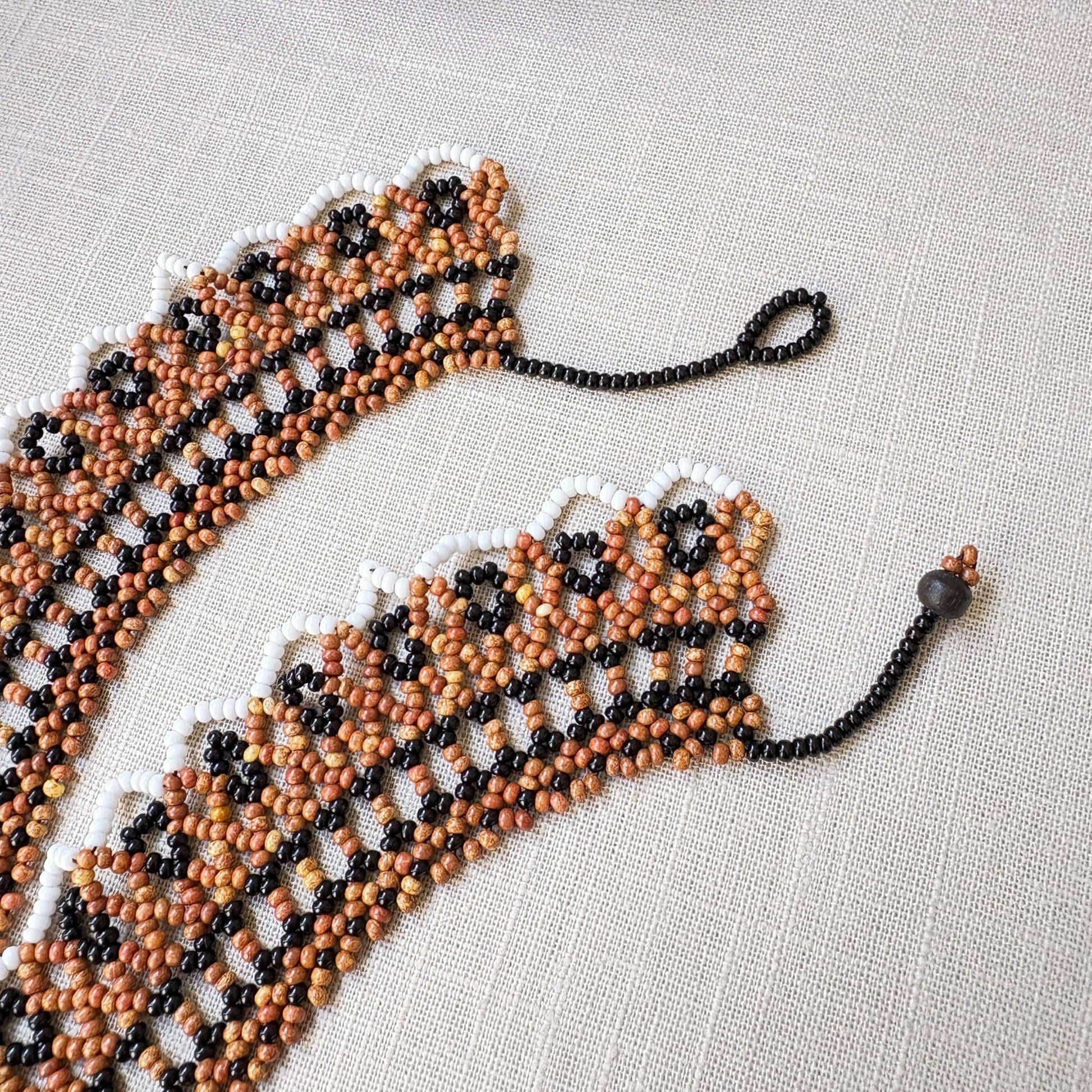 Collier en perles de verre (miçanga) ras de cou marron noir blanc et beige - Ethnie Wai Wai Collier Ethnie Wai Wai localisée dans les états de l' Amazonas, Pará et Roraima dans le Nord du Brésil. 