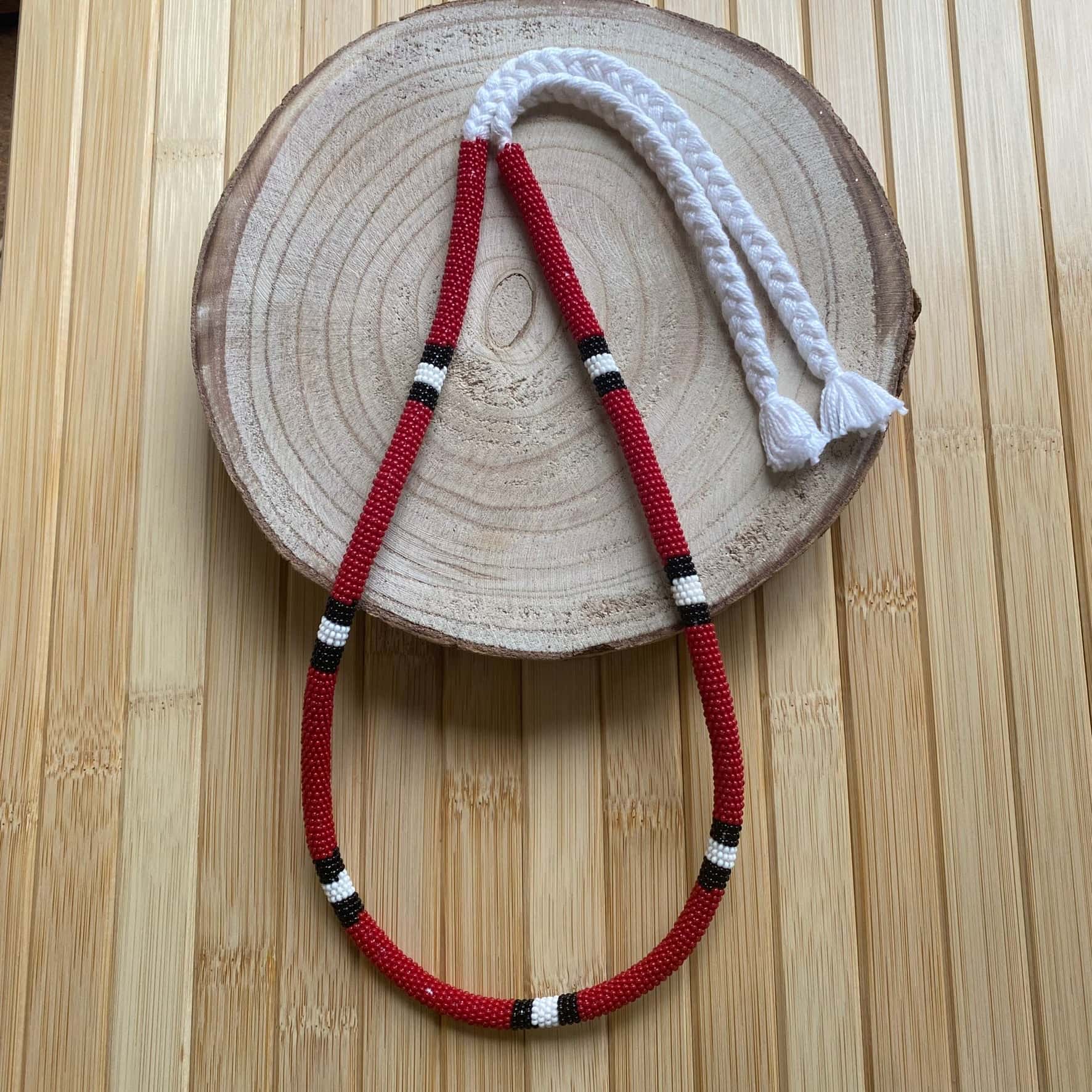 Collier en perles de verre (Miçanga) - serpent corail rouge bordeaux - noir blanc noir - long - Ethnie Mehinako Collier Ethnie Mehinako, localisée dans le Parc Indigène du Xingu dans l' état du Mato Grosso au Centre-Ouest du Brésil. 